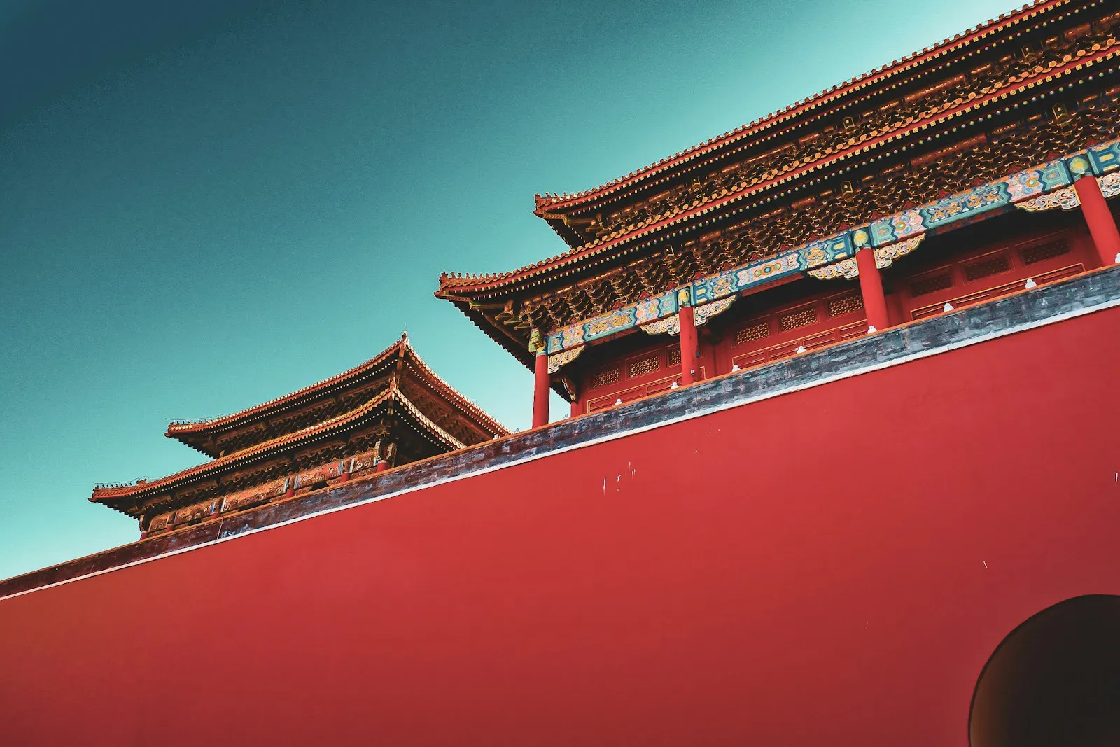 a red wall with a building in the background